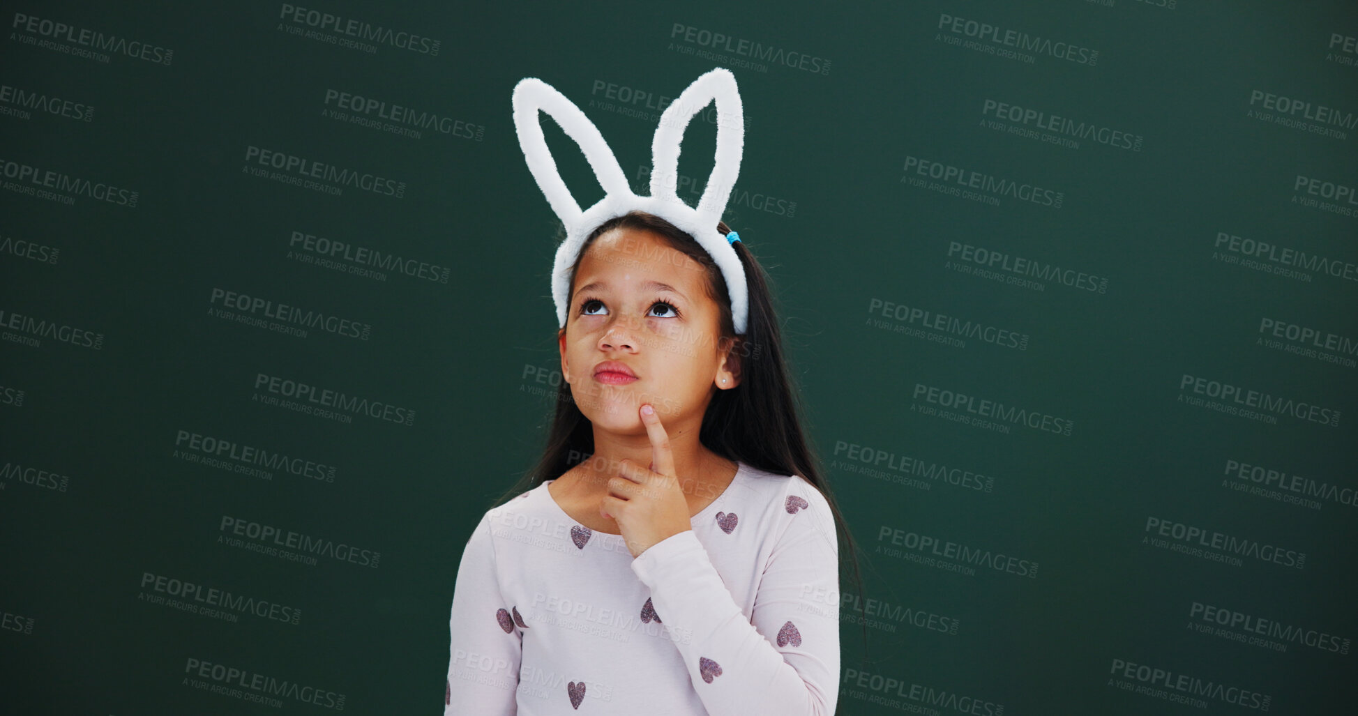 Buy stock photo Bunny ears, Easter and thinking with girl child in studio for holiday ideas or planning. Choice, decision and mockup space with thoughtful kid isolated on green background for selection or vision