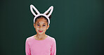 Portrait, bunny ears and girl in studio, easter celebration and happiness on green background. Mockup space, kid and child with confidence, promotion and announcement with rabbit costume and festival