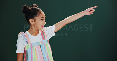 Buy stock photo Child, girl and pointing to presentation in studio for promo news, sale announcement or mockup. Happy, kid and advertisement space on green background for coming soon information, offer and bargain