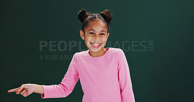 Buy stock photo Studio, portrait and child with smile, pointing and happy for presentation, discount or mockup space. Green background, advertising and girl with offer alert, deal and kid with promotion news or sign