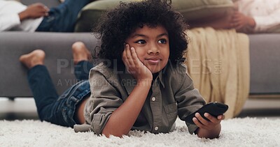 Buy stock photo Watching tv, child and carpet in living room with remote, relaxing and resting on school holiday. Young boy, laying and browsing videos for cartoons, series and streaming for vacation with family