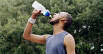 Fitness, man and water in nature for health, wellness or exercise break with hydration liquid. Bottle, person and thirsty runner with drink outdoor for workout recovery, minerals and sports nutrition