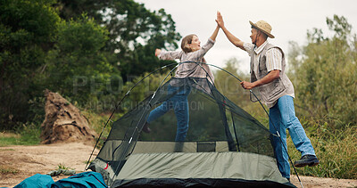 Buy stock photo Couple, camping and high five by tent, happy or excited for achievement, goal or holiday in bush. People, man and woman in woods with interracial love, celebration or success for shelter construction