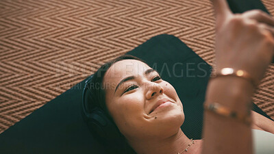 Buy stock photo Fitness, headphones and smile with yoga woman in home living room for holistic or wellness routine. Music, text message and typing with Asian person on apartment floor for social media from above
