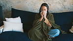Blanket, woman and sick with blowing nose on sofa from viral infection, disease and flu recovery. Respiratory illness, person and sneeze in tissue from influenza, nasal congestion and fever in home