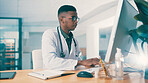 Black man, doctor and typing on computer for healthcare history, report or insurance records. Desktop, serious medical worker and reading email for wellness, clinic schedule or research in office