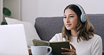 Woman, book and laptop with headphones in home for elearning subscription, listen and education. Person, computer and student with notebook, attention and online course in living room at apartment