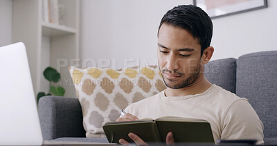 Buy stock photo Man, notebook and writing with laptop in home for publication review, remote work or story planning. Freelance writer, person or tech in living room for manuscript revision or proofreading newsletter