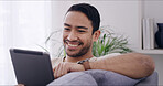 Smile, man and relax with tablet at house for browsing website, social media and movie choice. Happy, person and digital for surfing internet, streaming film and entertainment subscription in lounge