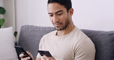 Buy stock photo Credit card, phone and reading with man on sofa for online shopping, banking app and password. Digital purchase, coupon code and ecommerce with person in living room of home for bills and fintech