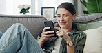 Woman, smile or scroll on sofa with phone for social media, text message chat and online dating. Female person, reading and browsing on couch with tech for mobile app, internet or networking in home.