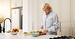 Home, fruits and old woman in kitchen, cutting and wellness with breakfast, nutrition and lens flare. Apartment, pensioner and mature person with ingredients, recipe and healthy snack with treat