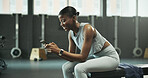 Black woman, gym and smile with phone for social media, message or online post and break. African person, sports center and fitness with laugh on internet for funny video, meme or notification