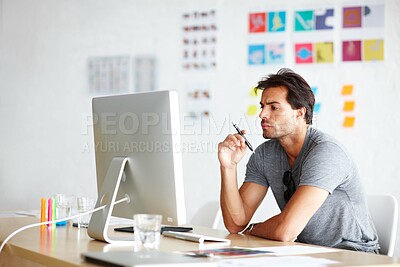 Buy stock photo A handsome young man looking bored in front of his computer
