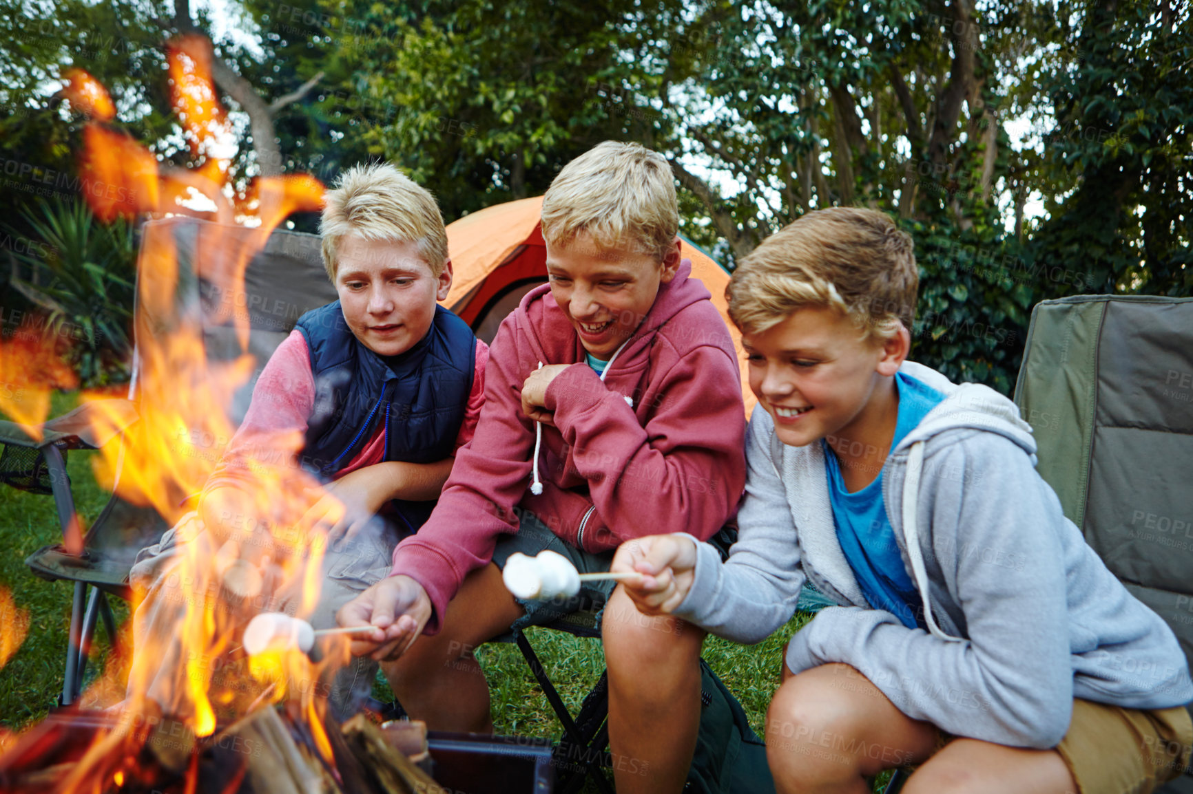 Buy stock photo Boys outdoor, laugh and fire with marshmallow for childhood memories, connection or bonding together. Children, friends and happiness in nature with flame for smores treat, snack or camping activity.