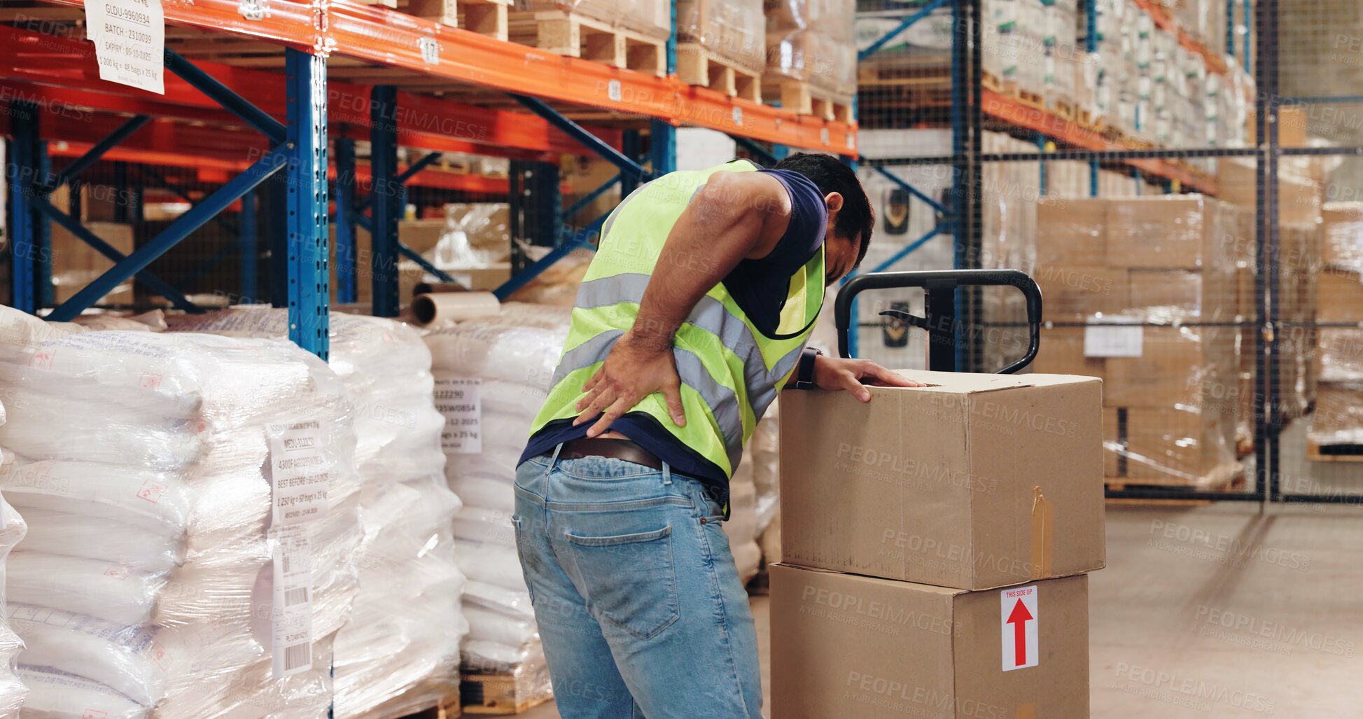 Buy stock photo Pallet truck, man and back pain in warehouse with transport, safety and storage for distribution or delivery. Freight operator, logistics and stock in cardboard for shipping, cargo and inventory
