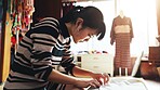 Fashion designer, seamstress and Asian woman with clothes in workshop for stitching, manufacturing or process. Small business, boutique and people with material, fabric or textile for tailor in Japan