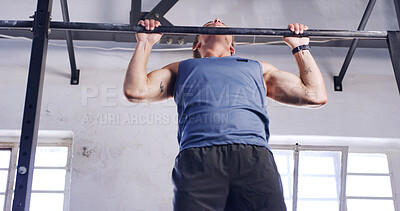 Buy stock photo Low angle, pull up bar and fitness with man in gym for arm exercise, health and challenge. Strength training, bodybuilder and workout with person in sports club and equipment for athlete and muscle