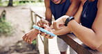Hands, outdoor and people with smartphone, fitness and bonding together with social media. Friends, man and woman with cellphone, internet and digital app to track progress, connection and network