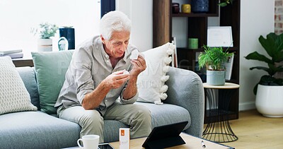Buy stock photo Medication, video call or old man on sofa with tablet, pill research or telehealth check for dose. Healthcare, online chat or male person in house with tech, reading label and wellness in retirement.