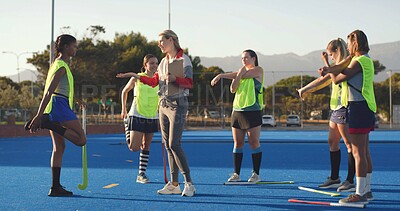 Buy stock photo Women, hockey and players with coach, stretching and game plan with feedback, exercise and wellness. People, outdoor and instructor with athletes, workout and advice with practice, turf and fitness