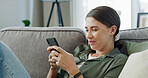Woman, relax and scroll on sofa with phone for text message, social media chat or communication. Person smile, reading and typing on couch with tech for mobile app, internet or conversation in home.