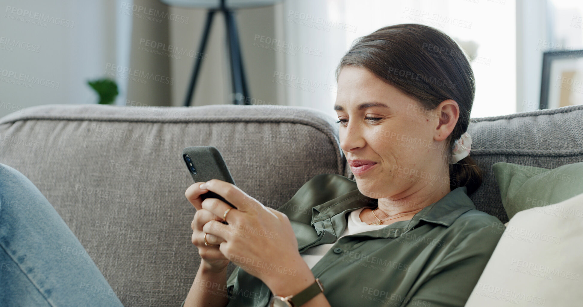 Buy stock photo Woman, relax and scroll on sofa with phone for text message, social media chat or communication. Person smile, reading and typing on couch with tech for mobile app, internet or conversation in home.