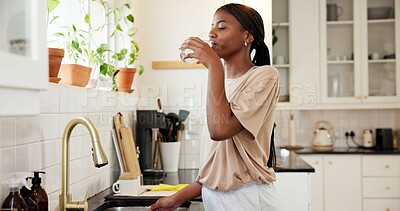 Buy stock photo Home, thirsty and woman drinking water in kitchen for hydration, natural nutrients or detox. Apartment, black person and liquid beverage at faucet for refreshing drink, wellness and digestive health