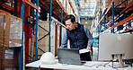 Man, documents and stress at warehouse with laptop, checklist or lost invoice for shipping order. Person, computer and paperwork for supply chain, notes and search with inventory management at plant