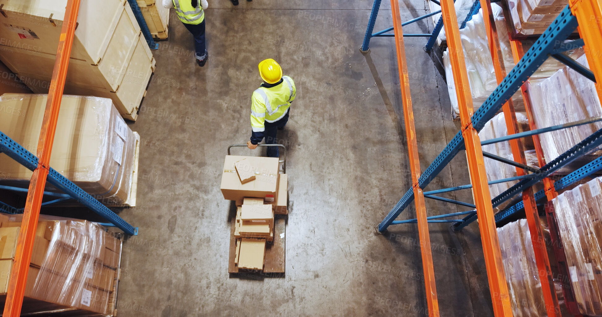 Buy stock photo Logistics, man or walking with trolley in warehouse to transport boxes, supply chain or shipping. Above, distribution picker and moving packages for inventory export, storage management and delivery
