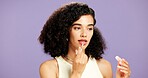 Cosmetics, lip gloss and skincare with woman in studio for hydration or moisturizer application. Aesthetic, beauty and mouth product with African model isolated on purple background for dermatology