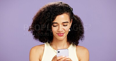 Buy stock photo Woman, typing or reading with phone in studio for online chatting or texting on a purple background. Female person, model or smile with mobile smartphone for app connectivity, network or web service