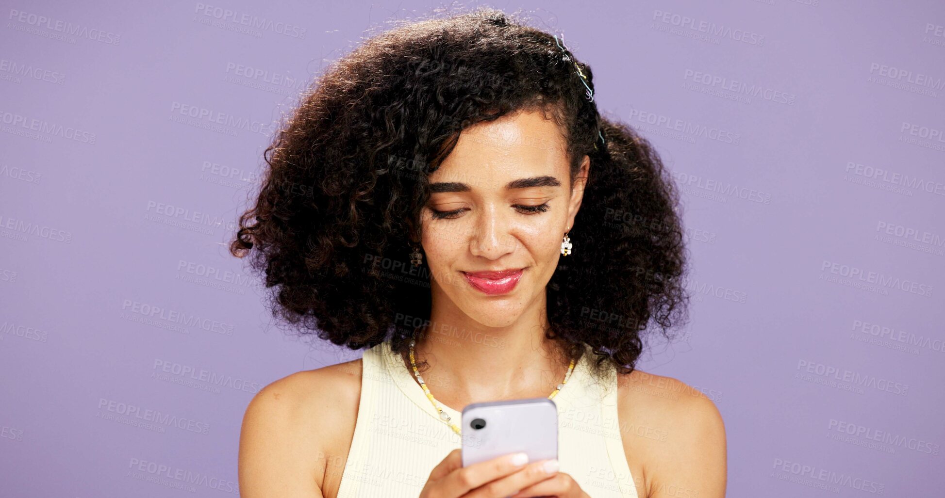 Buy stock photo Woman, typing or reading with phone in studio for online chatting or texting on a purple background. Female person, model or smile with mobile smartphone for app connectivity, network or web service
