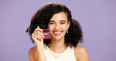 Buy stock photo Beauty, lipstick and portrait of happy woman in studio for makeup advice or recommendation. Choice, product and variety with model isolated on purple background for cosmetic marketing or promotion