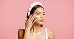 Moisturizer, skincare and woman in studio with face cream, beauty and facial routine for wellness. Cosmetic, hydration and female person with dermatology lotion, spf or sunscreen by pink background.