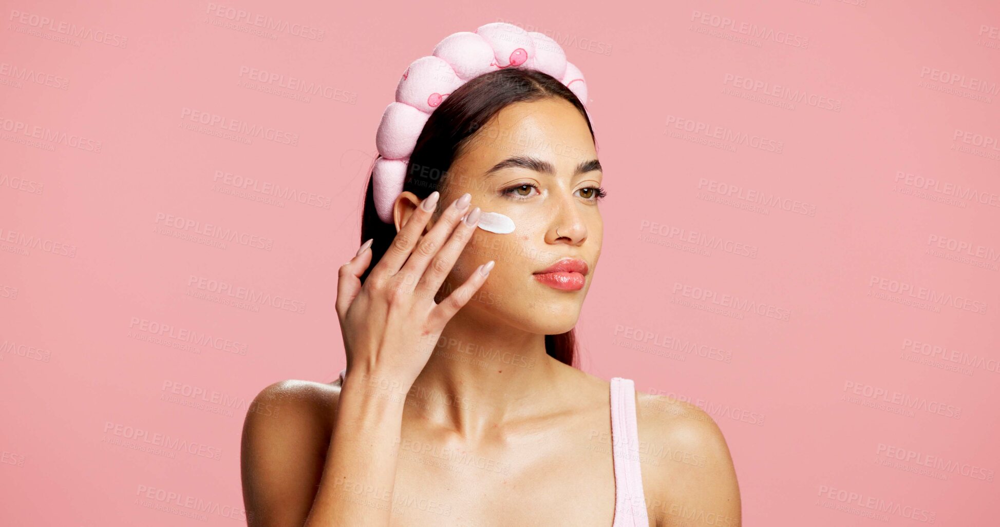 Buy stock photo Moisturizer, skincare and woman in studio with face cream, beauty and facial routine for wellness. Cosmetic, hydration and female person with dermatology lotion, spf or sunscreen by pink background.