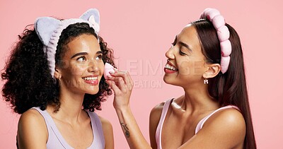 Buy stock photo Makeup, friends and women in studio with sponge, coverage or foundation in beauty routine. Facial, cosmetic and people with blender on pink background for product application or bonding in self care