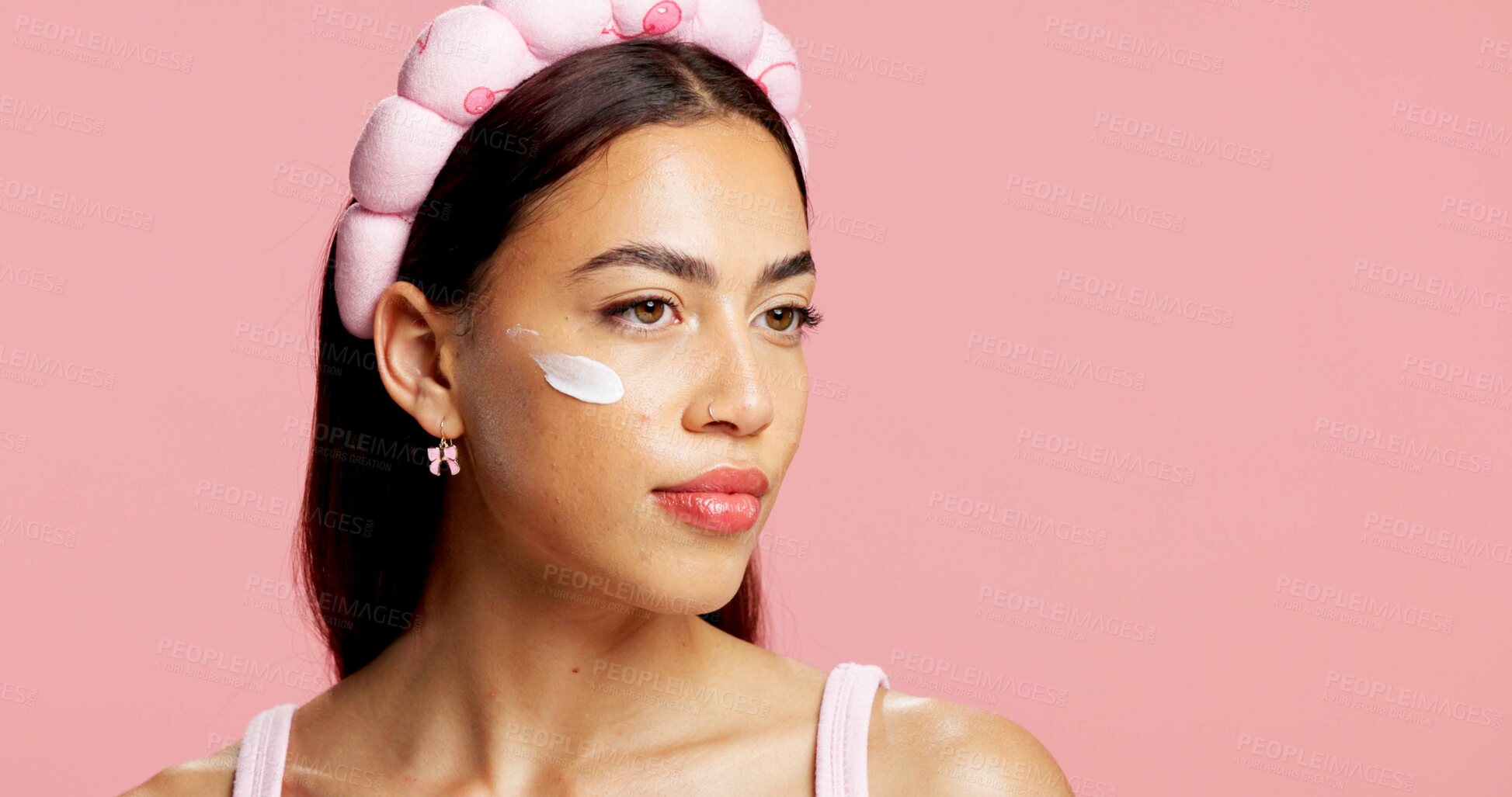 Buy stock photo Thinking, woman and lotion for skincare in studio for swatch test, hydration and healthy skin. Vision, person and cream for moisturizing, smooth textures and spf cosmetics for glow on pink background