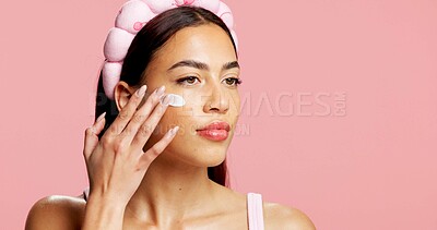 Buy stock photo Thinking, woman and sunscreen for skincare in studio for hydration, healthy skin and collagen. Mockup space, person and lotion for moisturizing, smooth textures and spf benefits on pink background