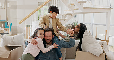 Buy stock photo Parents, children and play in new home, portrait and happy for moving, hug and boxes on sofa in lounge. People, mom and dad with kids on shoulders, excited or relocation with real estate investment