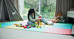 Building blocks, relax and game with kid in home for learning, creative puzzle and growth. Child development, problem solving and wooden toys with girl in playroom of house for solution and shapes