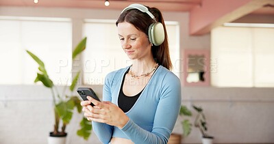 Buy stock photo Fitness, headphones and woman in studio, smartphone and listening to music, app and sound. Cellphone, audio and happy person in health club, podcast and radio with playlist album, exercise or pilates