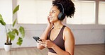 Phone, music and happy woman in studio for fitness, streaming podcast or listening to sound. Mobile, health club and person with headphones for internet audio, wellness and radio on exercise break