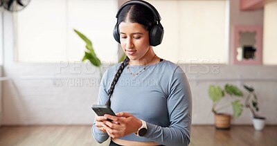 Buy stock photo Phone, headphones and woman in studio for fitness music, radio or streaming sound on break. Mobile, audio and person in health club for online podcast, exercise and listening to playlist on internet
