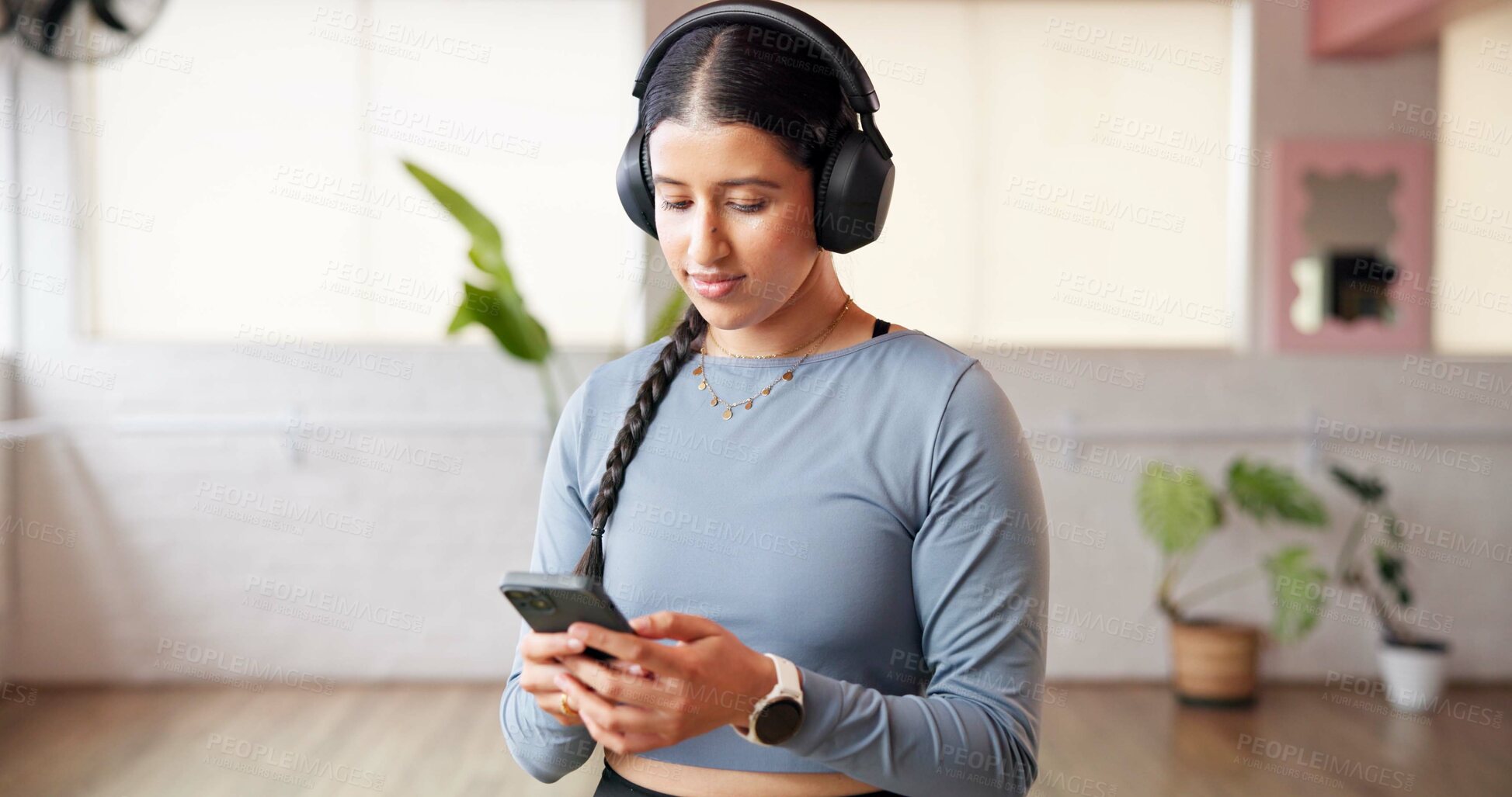 Buy stock photo Phone, headphones and woman in studio for fitness music, radio or streaming sound on break. Mobile, audio and person in health club for online podcast, exercise and listening to playlist on internet