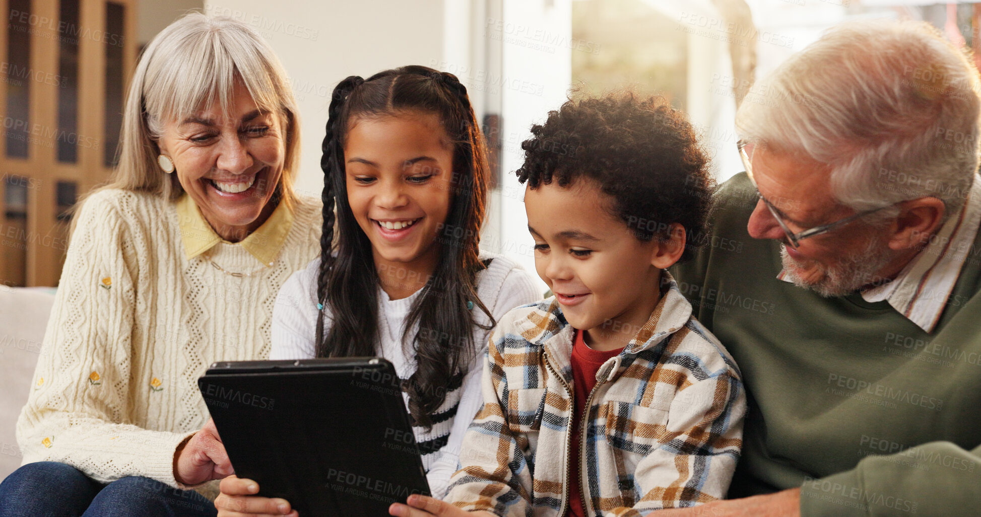 Buy stock photo Tablet, relax and grandparents with siblings on sofa in home for watching movie, series or show. Happy, digital technology and senior people with kids for streaming film together in living room.