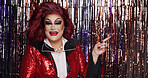 Pride, drag artist or streamer decoration with makeup for transformation, beauty or performance. Portrait, LGBTQ person or performer for gender exploration, alter ego or pointing on curtain backdrop.