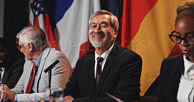 Buy stock photo Man, flags and portrait on panel at conference, happy and pride with international delegation for peace. Mature person, politician and global leader with group, smile or negotiation for war ceasefire