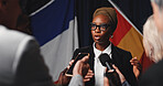 Woman, press conference and talk with flags at international seminar, journalist group or interview at event. Person, speaker or ambassador with media, mic and ceasefire announcement for global war