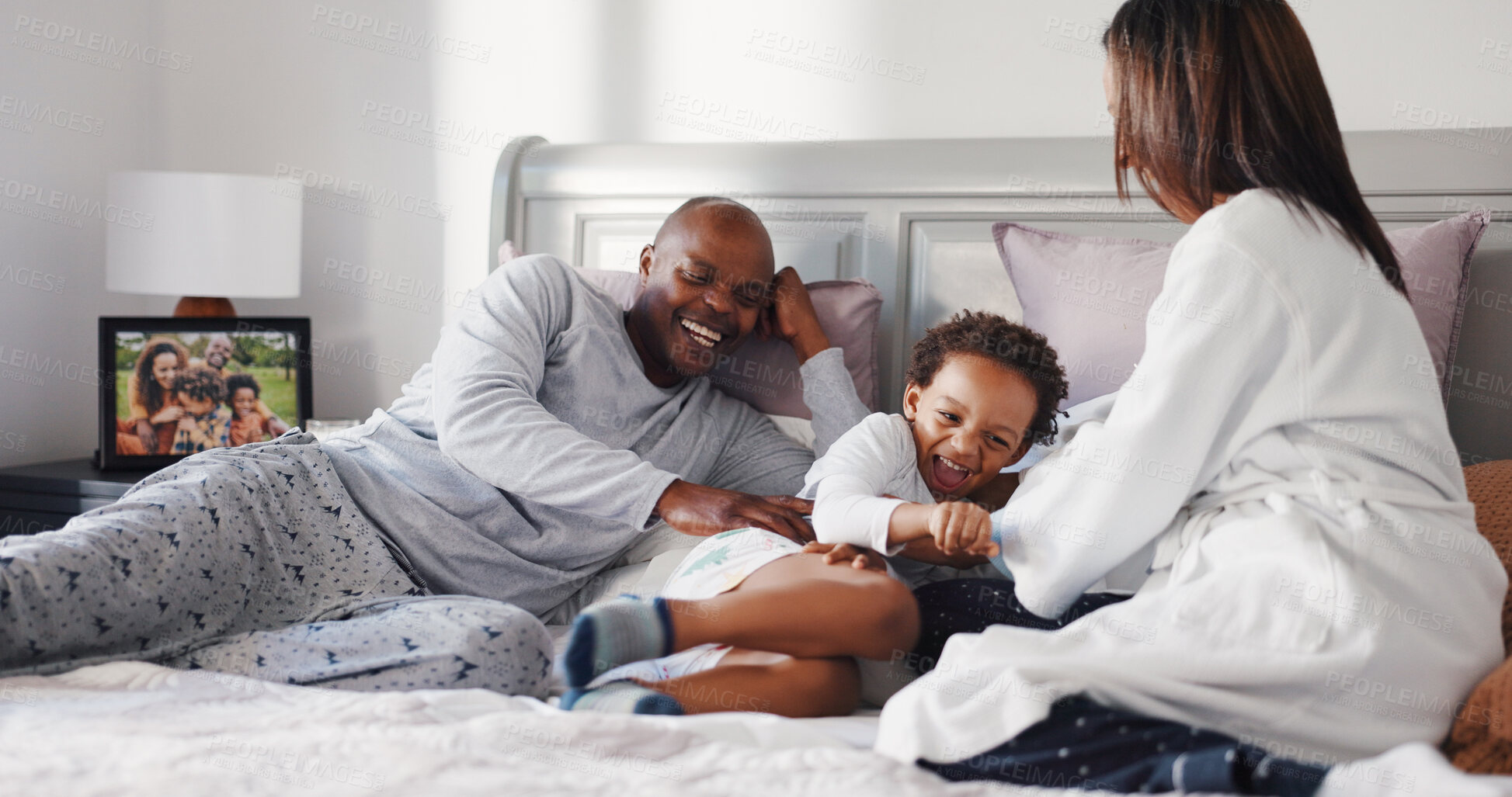 Buy stock photo Father, mother and child in bedroom with laughing, love or bonding together for support. African family, son and parents on bed of home for tickle game, humor and happiness or connection in morning
